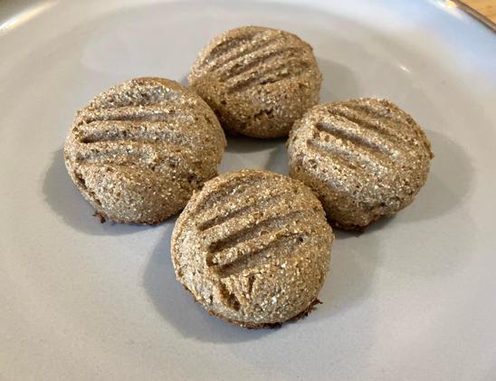 Four round rye cookies on a plate, with the imprint of a fork on top.