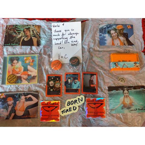 package contents laid out: 4 postcards, a CD, a cassette, a motivation dog tag, a note, 3 trading cards, a glowing sticker and 2 more stickers