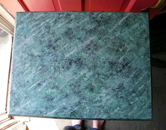 A close-up of a hand-painted marbleized effect. Light green with black spots and white streaks.