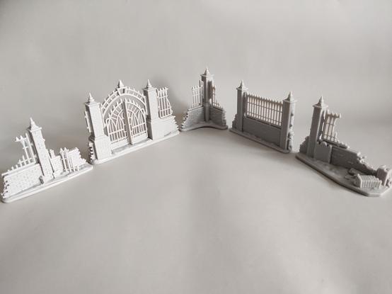 Wargames terrain - five brick wall pieces in various stages of ruin, arranged in an 'L' shape pointing away from the camera.