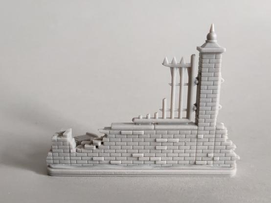 Wargames terrain - partially ruined wall piece with one intact brick column and one destroyed brick column, front view.