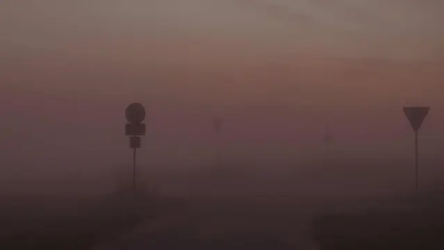 Dichter orangegrauer Nebel , ein paar Schilder sind schwarz zu erkennen