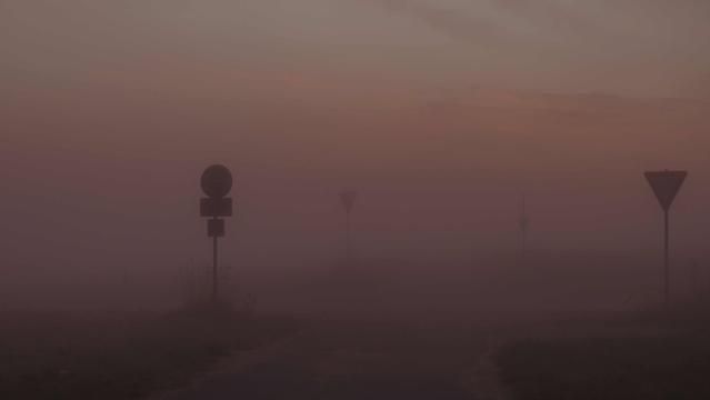 Dichter orangegrauer Nebel , ein paar Schilder sind schwarz zu erkennen