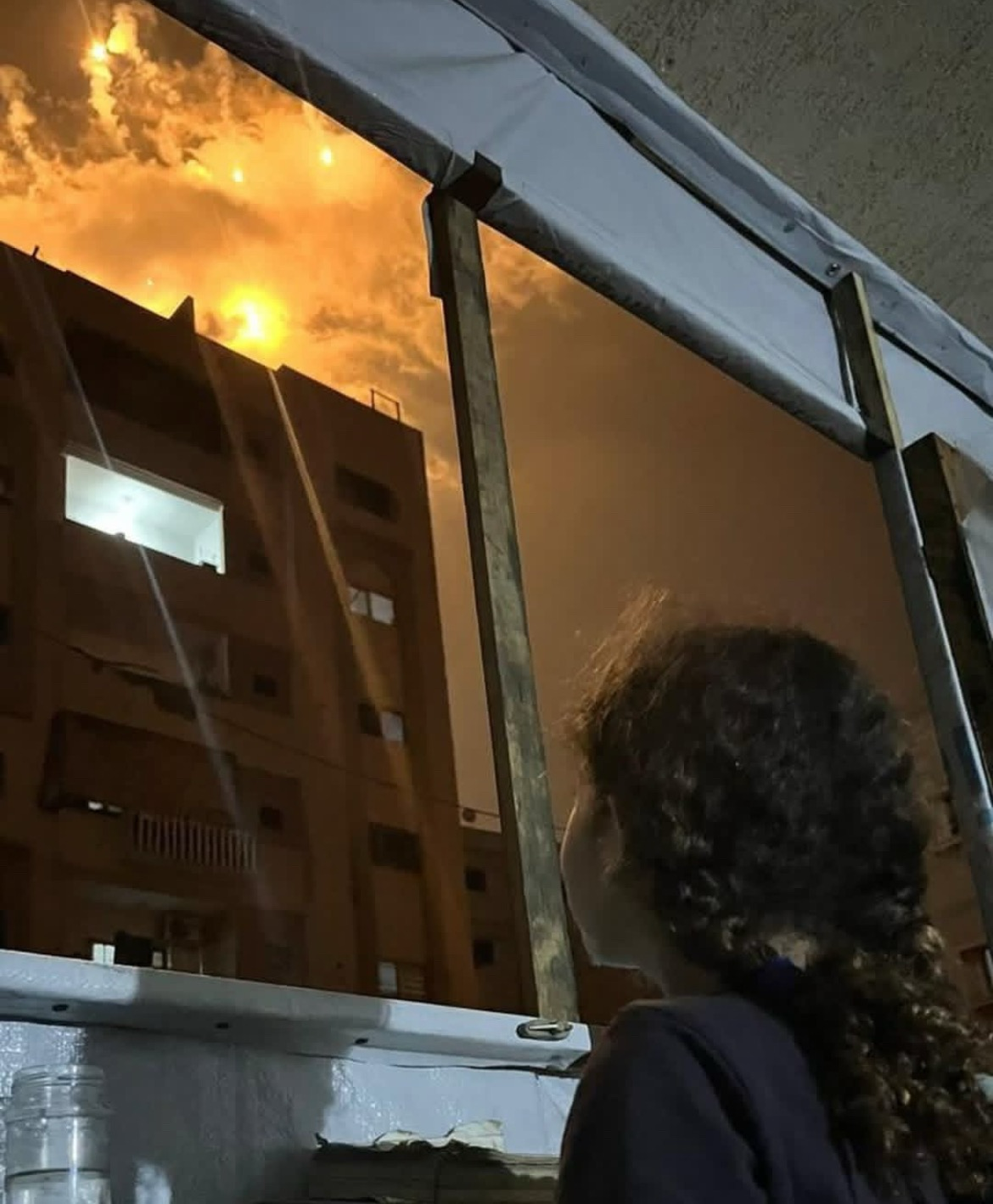 A little girl lifts her eyes to the sky lit up with incendiary flares... a scene that captures the terror of childhood in Gaza under Israeli fire.