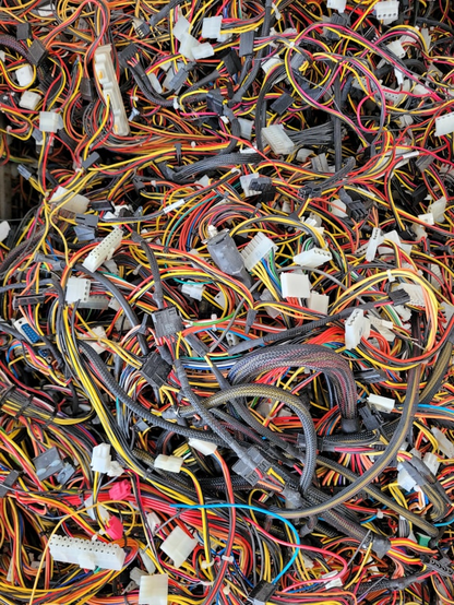 Photograph showing a tangle of wires and cables in yellow, blue, red, dark grey. There are bits of white plastic holding some of the cables into groups but it looks like a complicated mess. Image thanks to Nathan Cima on Unsplash.