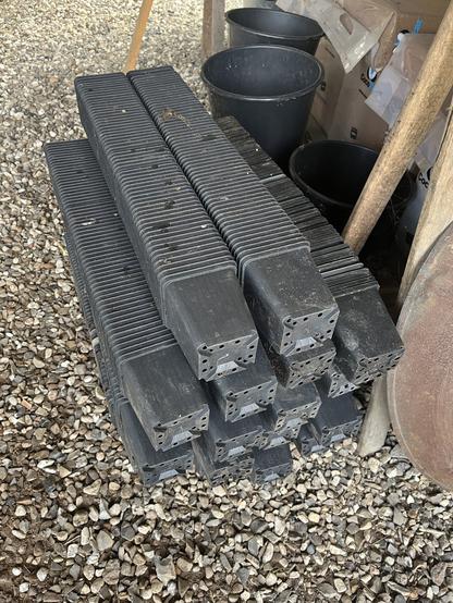 Hundredevis af stablede firkantede potter i en bunke