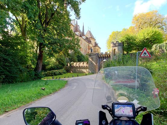 view from a motorbike to a castle at a road corner