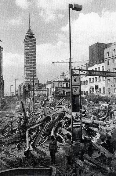 Imagen en blanco y negro que muestra la devastación provocada por el terremoto de 1985 en Ciudad de México, con edificios en ruinas y el emblemático edificio Torre Latinoamericana al fondo.