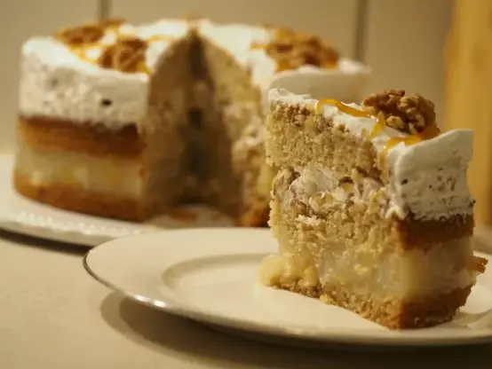 Die angeschnittene Torte im Hintergrund und im Vordergrund ein Stück auf einem Kuchenteller