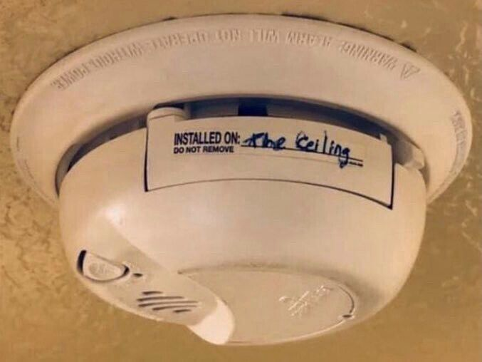 Sticker on a smoke alarm has an “INSTALLED ON” field intended for a date. “The Ceiling” is filled into the field.