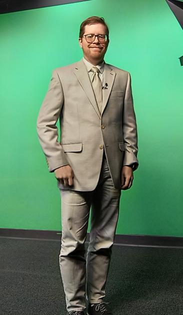 A picture of me and what I am wearing for our newscasts the evening of September 11, 2025.  I am in front of a green screen, which prevents me from wearing anything green or light green.  This means I can't support the Green Bay Packers when they play at the same time, other than a dark green bowtie.  Today's game is an exception, since they will be wearing their all-white alternative uniform this evening.  So in support of them, I'm in my all white patchwork suit with a white shirt, white pants, white jacket, and slightly off-white tie.