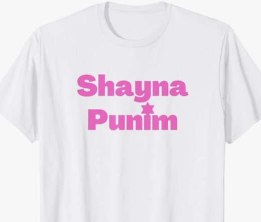 Shayna Punim is shown in pink lettering on a white T shirt.
