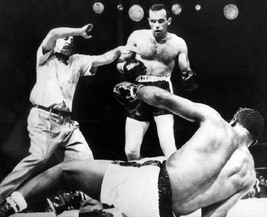 Ingemar Johansson knocks out Floyd Patterson for the world heavyweight boxing championship on 26 June 1959. Patterson was not “saved by the bell"; B&W photo of a referee intervening between two boxers, one of whom is lying on the ring floor