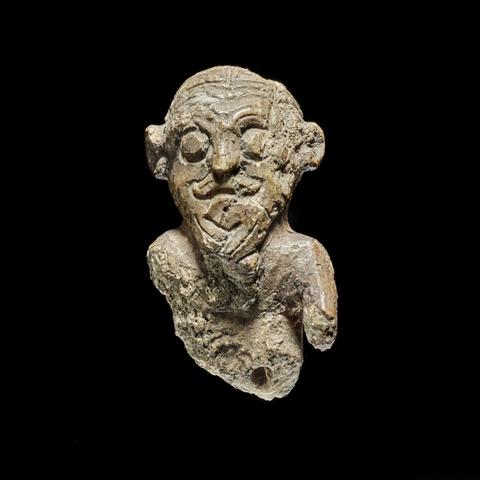 Mini-busto di un uomo vichingo del X secolo, intagliato in avorio di tricheco, con dettagli sulla pettinatura e un pizzetto intrecciato.