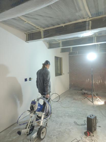 Duane wheels the airless sprayer into the studio preparing to paint the newly constructed space.