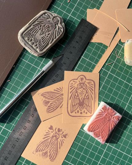 table de travail avec des mini cartes tamponnées, et 2 tampons gravés.