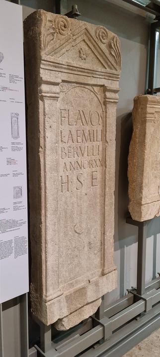 Foto eines römischen Grabsteins aus dem 2. Jahrhundert. Auf dem Grabstein steht "FLAVOS LA EMILI BERVLLI ANNORXX H S W"