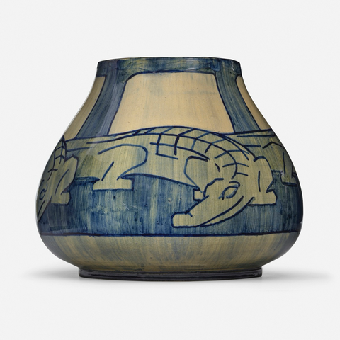 official auction photo of the alligator vase, front view 1 in white background  “Newcomb Pottery, also called Newcomb College Pottery, was a brand of American Arts & Crafts pottery produced from 1895 to 1940.[1] The company grew out of the pottery program at H. Sophie Newcomb Memorial College, the women's college now associated with Tulane University in New Orleans, Louisiana. … Early pieces at the Pottery closely reflected the arts and crafts era in which the Pottery was operating. The pottery often depicted Louisiana's local flora, done in blue, yellow and green high glazes.”  (additional info via Wikipedia)