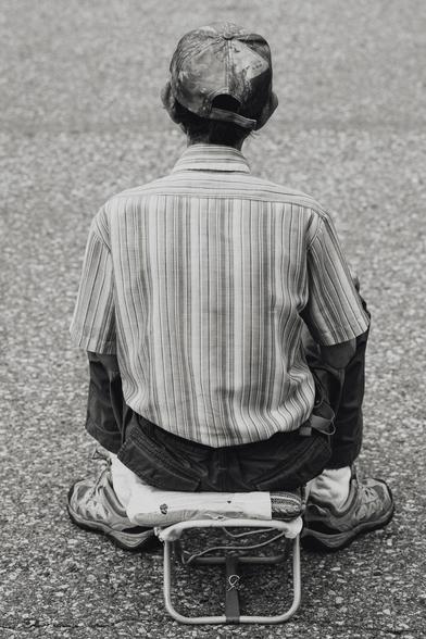 A small man rocks out in the front row of a street concert.