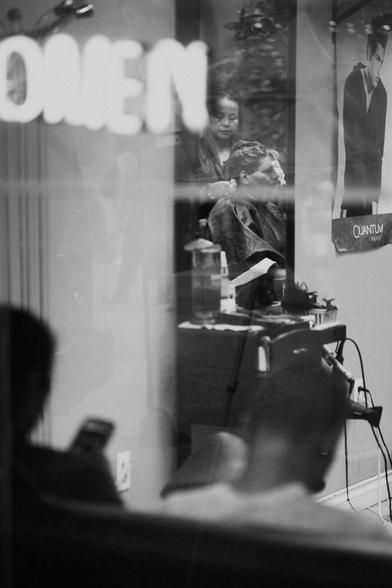 A woman sits in a chair with tinfoil in her hair.