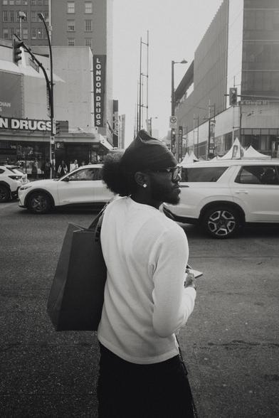 A man crosses a busy street in the city centre.