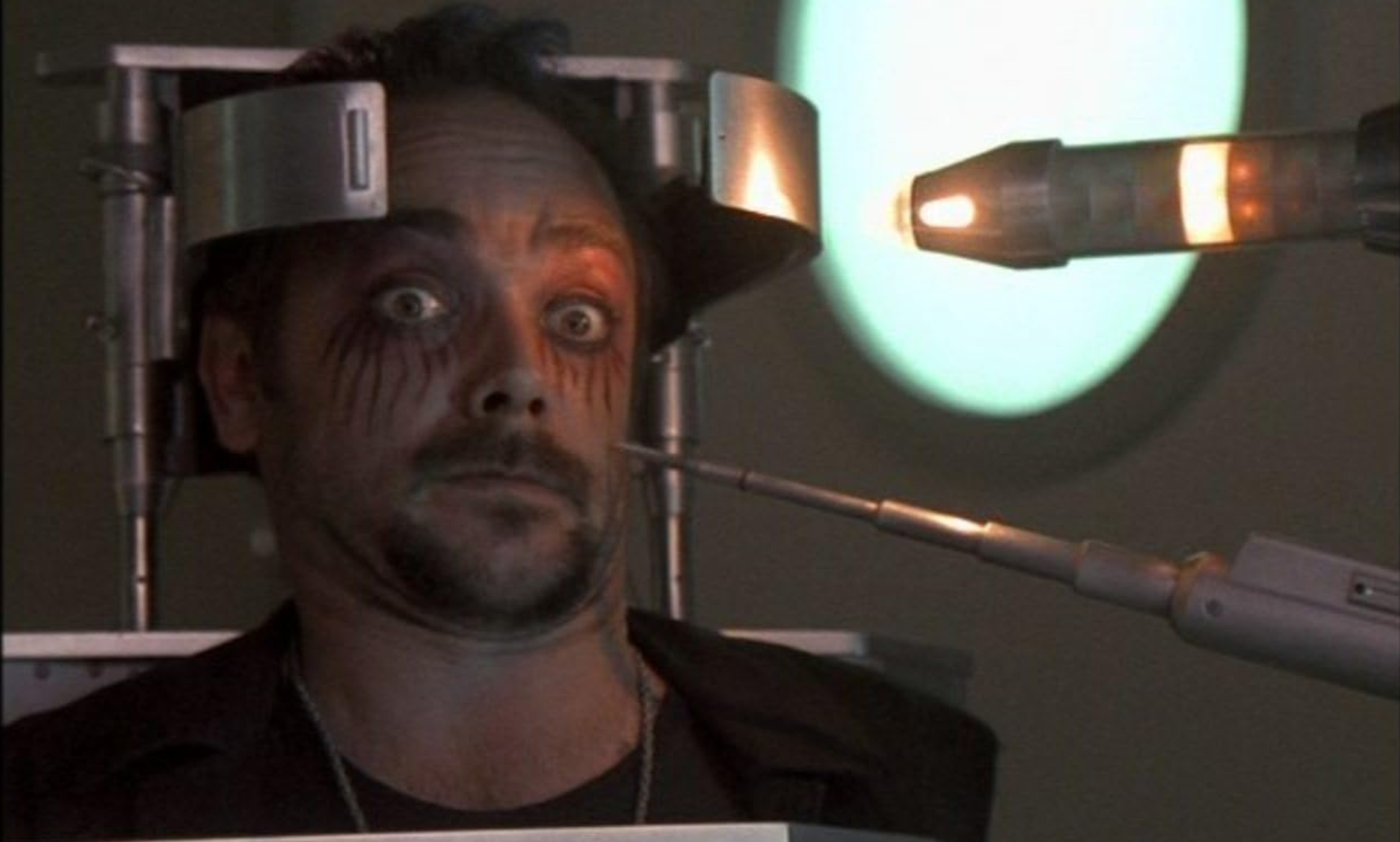 Choosing your Mastodon instance. A man is strapped into an upright medical restraint with some sort of probe pointed at this head.