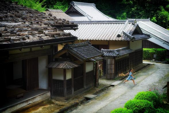 A young girl dashes out from an alley of old Edo era houses in Kanagawa Japan