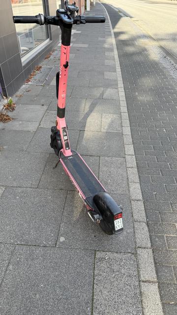 Das Bild zeigt ein pinkes Elektro-Scooter, das auf einem Gehweg geparkt ist. Das Scooter hat einen schwarzen Fußtritt und einen schwarzen Lenker mit einem Display und Griffen. Auf dem Schaft des Scooters ist das Logo "voli" und die Aufschrift "GPS" zu sehen. Der Scooter hat eine schwarze Scheibe am hinteren Teil und eine kleine Rücklichter. Die Nummer "161 KYI" ist auf der Rückseite angebracht. Der Gehweg besteht aus grauen Steinen, und im Hintergrund ist eine Straße mit einem Gebäude zu sehen.

Bereitgestellt von @altbot, privat und lokal generiert mit Ovis2-8B
