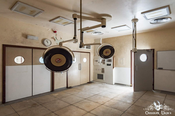 Operating theater with double doors and lights on ceiling. Another door stands open letting light in