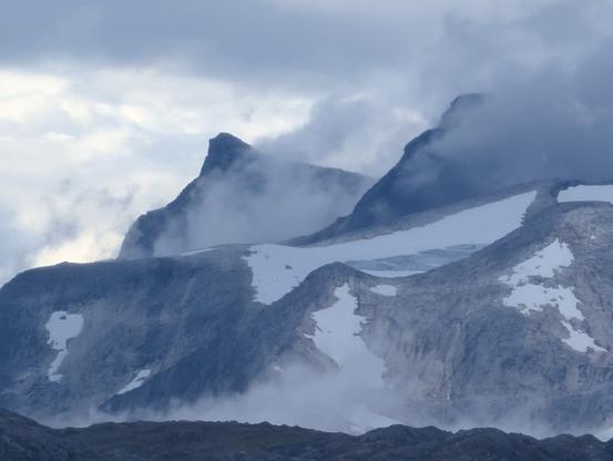 Mountain peak covered with ice/snow and clouds.