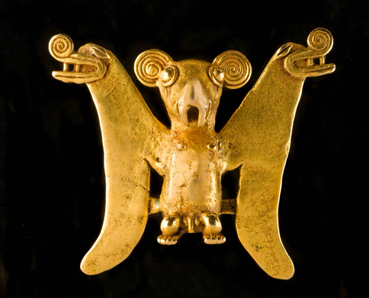 official museum photo of the object, front profile in black background Chiriqui gold pendant in the form of a bat, wings spread open and with zoomorphic heads on the upper tips