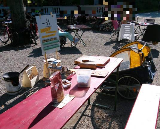 Vorn mein Stand mit Mehlen, mittog der Fahrradhänger, hinten mein Aufsteller und links unten der Kocher mit Wok.