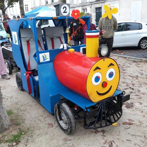 Petite locomotive à vapeur bleue, chaudron rouge et jaune avec un visage.