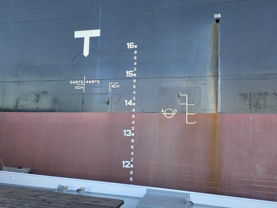 Außenhaut eines großen Schiffes im Mittschiffsbereich mit verschiedenen Marken und Beschriftungen
