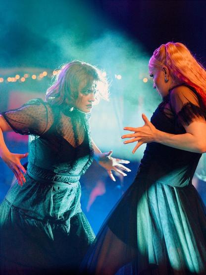 Kaksi tanssijaa, toinen hieman takakenossa ja toinen etukenossa katsovat intensiivisesti toisaan. Värikkäät valot valaisee toisen toisen tanssijan kasvoja. Molempien tanssijoiden kädet ovat hieman levällään, aivan kuin olisivat ottamassa toisensa tiukkaan syleilyyn.