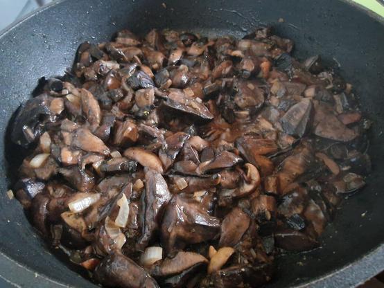 Pilze braten in einer Pfanne.