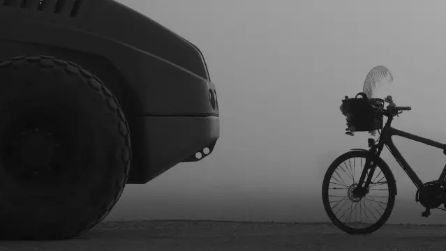 Schwarzweißbild, Ein Fahrrad steht einer großen Baumaschine gegenüber. Im Hintergrund ein Feld im Nebel.
Fahrrad und Baumaschine scheinen zu kommunizieren