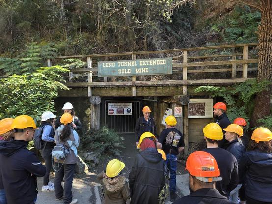 delegates wearing hard hats outside a mine entrance