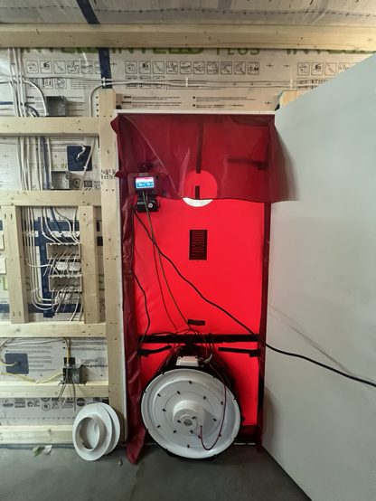 Blower door test equipment being set up in new construction.
