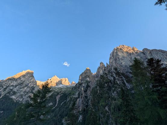 Bergspitzen die von Sonnenstrahlen an den Gipfeln erleuchtet werden