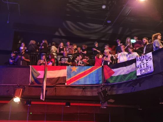 Palestine flags and a banner reading "Love Jews hate Zionist".