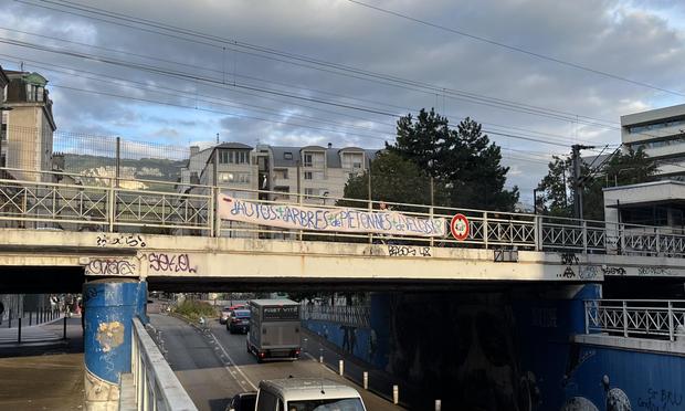 Banderole avec le slogan : «  moins d’autos : plus d’arbres plus de piéton•nes plus de vélos »