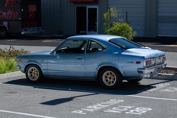 A vintage Japanese coupe in light metallic blue.