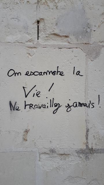 Tag sur un mur de tuffeau : "on escamote la vie ! Ne travaillez jamais !"