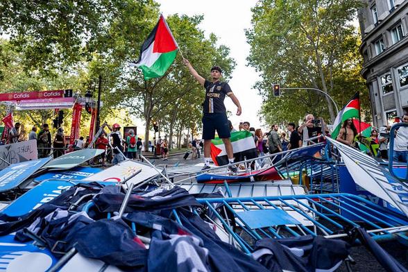 Un manifestante ondea una bandera palestina en las barricadas creadas con vallas y carteles de La Vuelta, el 14 de septiembre de 2025, en Madrid. (Alberto Gardin / Eurasia Sport Images / Getty Images)