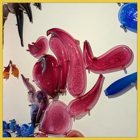 Detail of the glass object, red curved in th centre, blue and brown at the edges