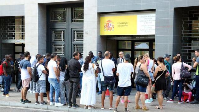 desenes de persones fan cua davant unaoficina d'estrangeria a Barceona (ACN/Miquel Codolar)