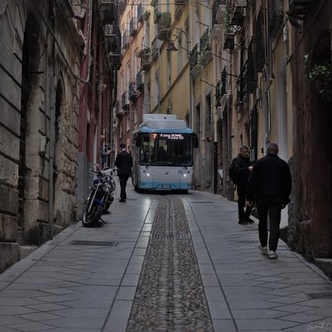 Approche d'un bus dans une ruelle étroite de la vieille ville de Cagliari