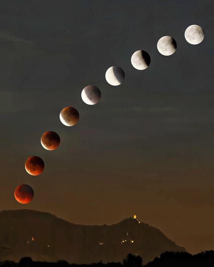 Die Phasen der Mondfinsternis vom Blutmond unten links bis zum Vollmond oben rechts über dem Drachenfels. Der Hintergrund ist rötlich-braun und geht nach oben in grau-blau über.