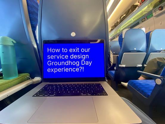 A laptop computer in a train, a slide says: “How to exit our service design Groundhog Day experience?”
